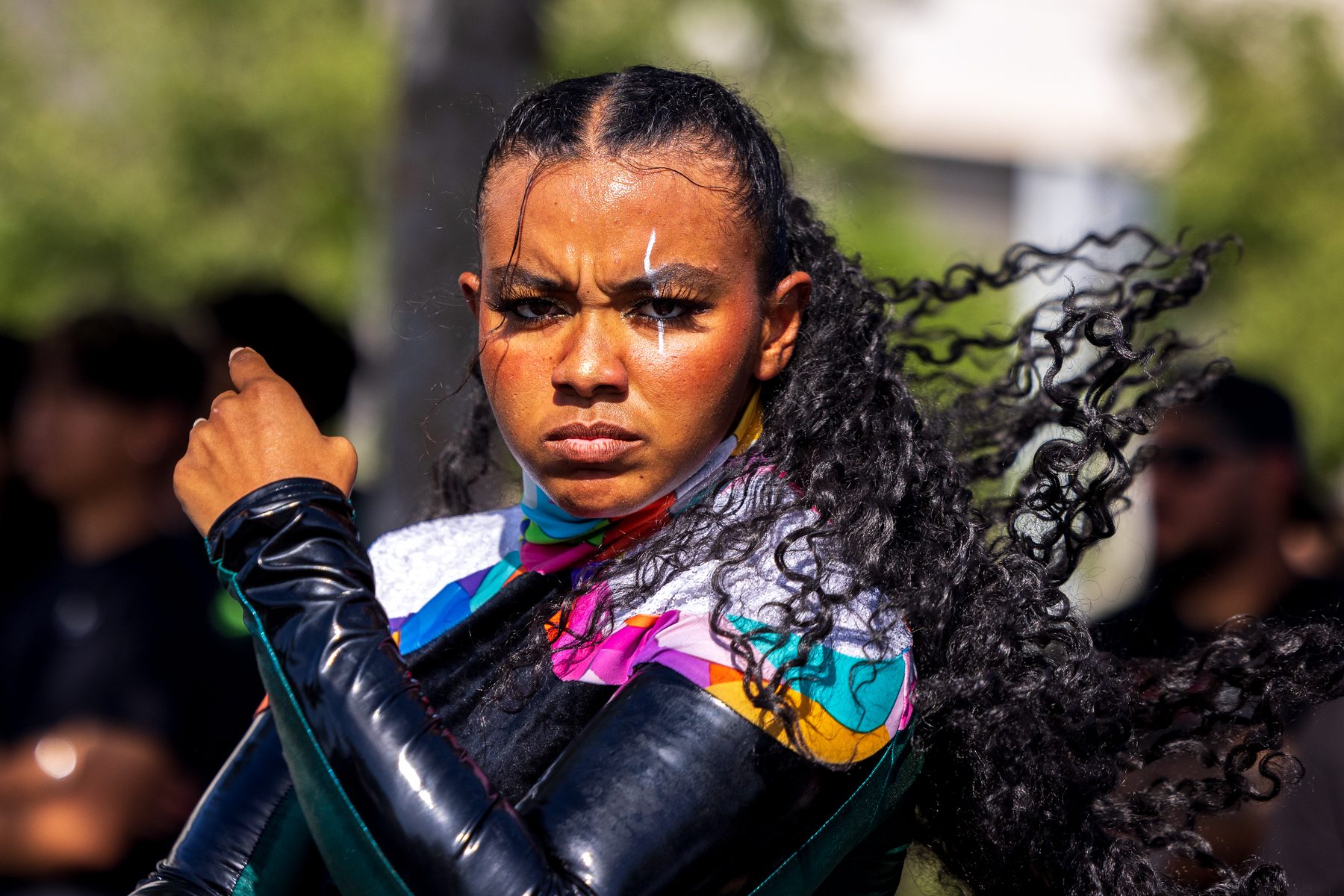 A winter percussion performer in black and teal, fierce in the moment
